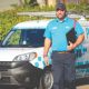 Poolwerx pool service professional standing beside branded service van