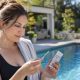 Homeowner testing swimming pool water chemistry with a test strip beside a backyard pool.